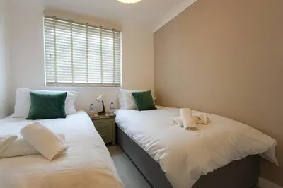 two beds sitting next to each other in a bedroom at Whiteside Apartment in Bathgate