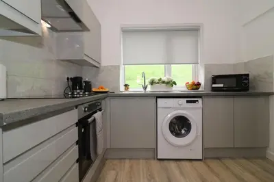 a kitchen with a washing machine and a sink at Signature - Huntley House in Glasgow
