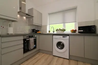 a kitchen with a washer and a washing machine at Signature - Huntley House in Glasgow