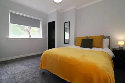 a bedroom with a large bed and a window at Signature - Huntley House in Glasgow