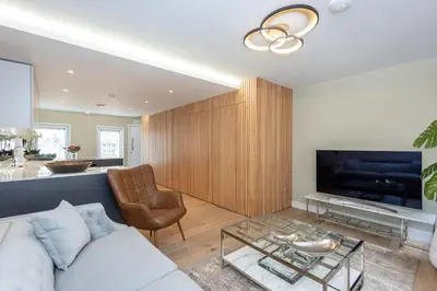 a living room with a white couch and a tv at Dragon Suites - City Centre 2 Bed Luxury Mews House in Edinburgh