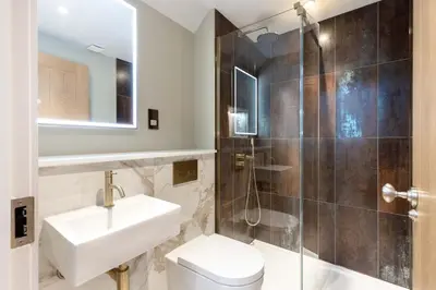 a bathroom with a sink and a shower and a toilet at Dragon Suites - City Centre 2 Bed Luxury Mews House in Edinburgh