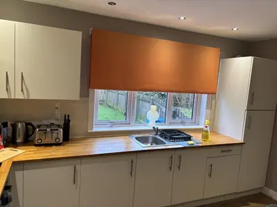a kitchen with white cabinets and a sink and a window at Burns House in Livingston