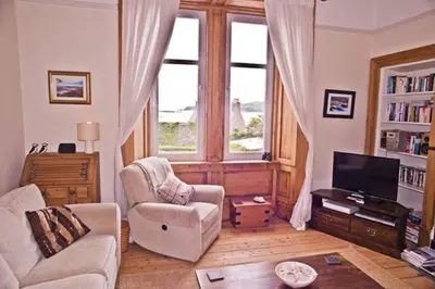 a living room with a couch chair and a television at 6 Killean Place in Campbeltown