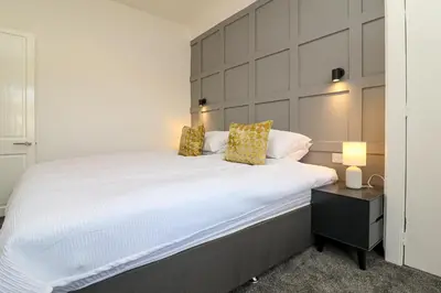 a bedroom with a large white bed with two pillows at Meadowfoot Haven in West Kilbride