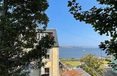 a house with a view of the water at Janeville Holiday Apartment in Ardrishaig