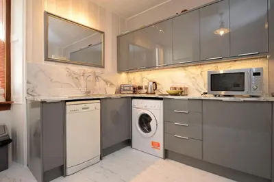 a kitchen with a washing machine and a microwave at Janeville Holiday Apartment in Ardrishaig