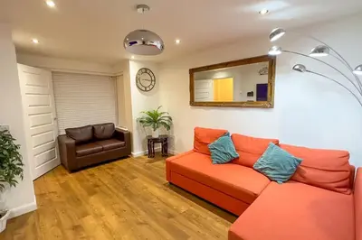a living room with a couch and a mirror at 4 Bed complete Home in Edinburgh Near Airport in Edinburgh