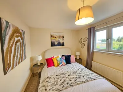 a bedroom with a bed with colorful pillows at 2 Bed Apt, 4 beds with Parking in Edinburgh
