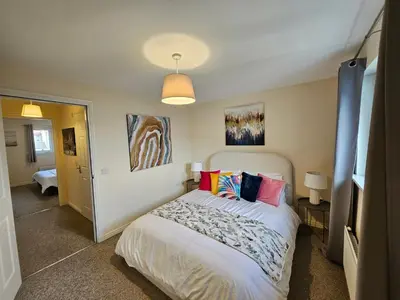 a bedroom with a bed with colorful pillows on it at 2 Bed Apt, 4 beds with Parking in Edinburgh