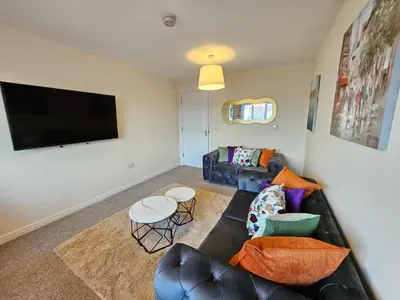 a living room with a couch and a flat screen tv at 2 Bed Apt, 4 beds with Parking in Edinburgh