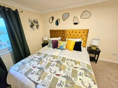 a bedroom with a large bed with a quilt on it at 4 bed house With 6 Beds in Edinburgh