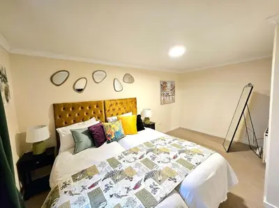 a bedroom with a large bed with colorful pillows at 4 bed house With 6 Beds in Edinburgh
