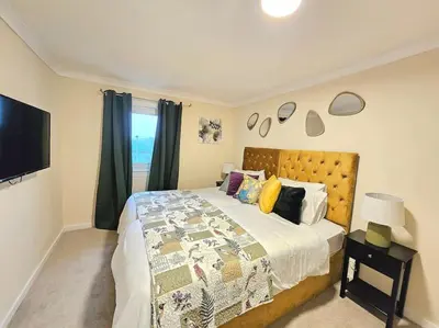 a bedroom with a large bed and a television at 4 bed house With 6 Beds in Edinburgh