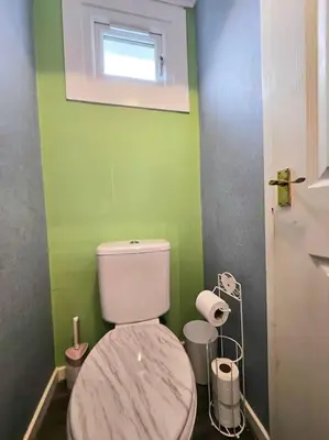 a bathroom with a white toilet in a green wall at 4 bed house With 6 Beds in Edinburgh