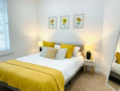 a bedroom with a large bed with yellow sheets at Harling House - Prestwick - 4 bedrooms in Prestwick