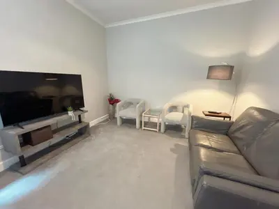 a living room with a couch and chairs and a television at Two bed apartment in Edinburgh