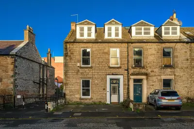 an old brick building with a car parked in front at Adam Drysdale House in Edinburgh