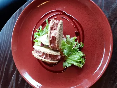 a red plate with a sandwich and lettuce on it at The Spinnaker Hotel in Gourock