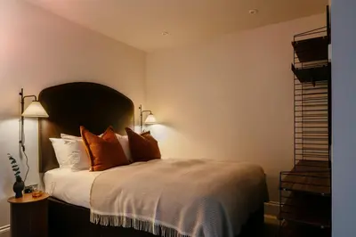 a bedroom with a large bed with orange pillows at 33 Castle Terrace in Edinburgh