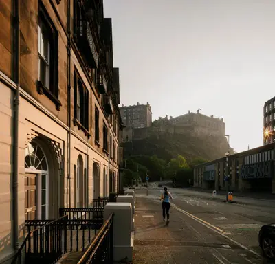 a woman walking down a street with a castle in the background at 33 Castle Terrace in Edinburgh