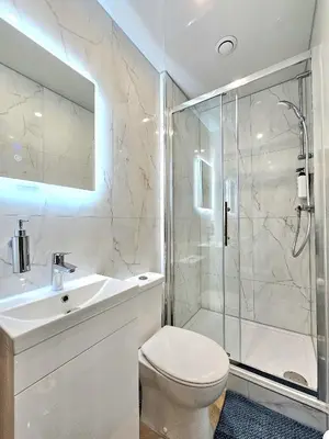 a bathroom with a toilet and a shower and a sink at Newly Renovated Gem - Free Parking & Modern Comfort in Glasgow
