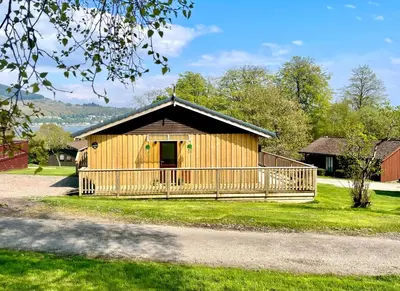 a large wooden building with a large porch at Harris's Cabin in Hunters Quay