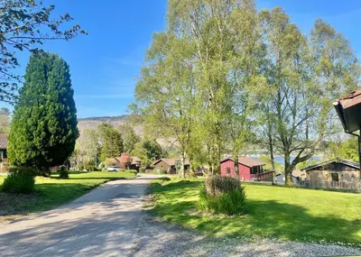 a road through a village with trees and houses at Harris's Cabin in Hunters Quay