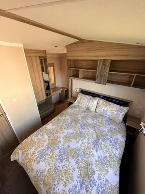 a bedroom with a large bed with pillows at 3-Bedroom Swift Caravan - Located in Uddingston, Glasgow at Maryville Caravan Site in Glasgow