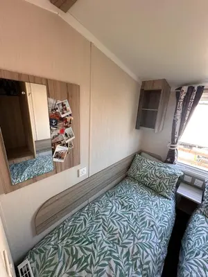 a small room with a bed and a mirror at 3-Bedroom Swift Caravan - Located in Uddingston, Glasgow at Maryville Caravan Site in Glasgow