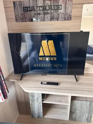 a flat screen tv sitting on top of a shelf at 3-Bedroom Swift Caravan - Located in Uddingston, Glasgow at Maryville Caravan Site in Glasgow