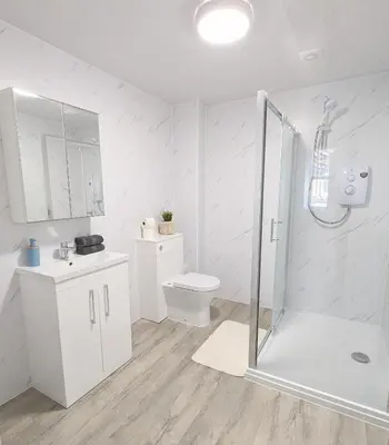 a white bathroom with a shower and a toilet at Campbeltown Central in Campbeltown