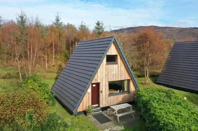 an overhead view of a wooden cabin with a black roof at 1 Bedroom Cabin with Mountain & Loch Views - Quiet Location between Glencoe & Ben Nevis in Onich