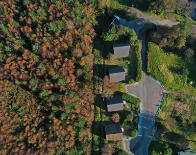 an overhead view of a forest with houses and a road at 1 Bedroom Cabin with Mountain & Loch Views - Quiet Location between Glencoe & Ben Nevis in Onich