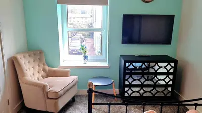 a living room with a chair and a television at The Rest in Tarbert