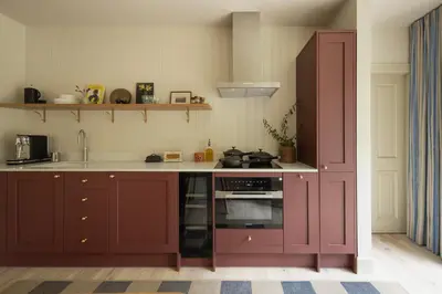 a kitchen with red cabinets and an oven at Penicuik Estate in Penicuik