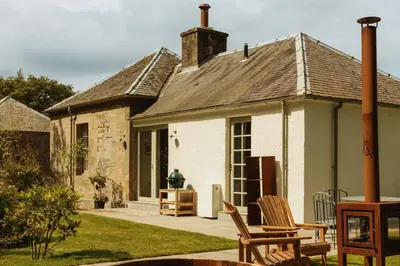 a house with two chairs sitting outside of it at Penicuik Estate in Penicuik