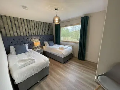 a bedroom with two beds and a window at Hot tub lodge with stunning view in Taynuilt