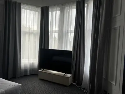 a tv sitting in a room with windows at Hotel Baba in Uddingston