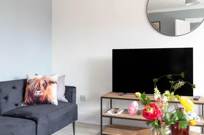 a living room with a couch and a large mirror at Blairmuire House in Broxburn