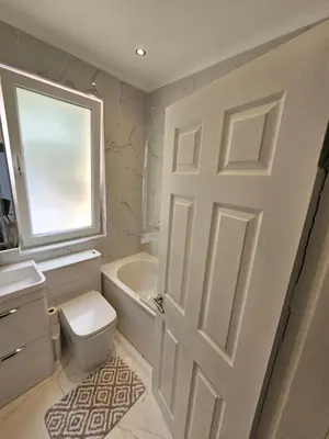 a bathroom with a white door and a toilet and sink at Lovely house with private parking! Glasgow! in Glasgow