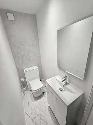 a bathroom with a toilet and a sink and a mirror at Lovely house with private parking! Glasgow! in Glasgow