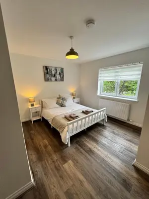a bedroom with a white bed and a window at Inchtavannach Apartment 1/1 in Bonhill