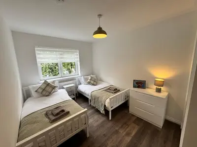 a bedroom with two beds and a window at Inchtavannach Apartment 1/1 in Bonhill