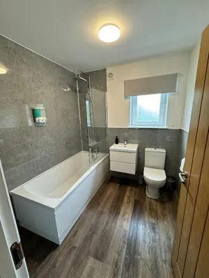 a bathroom with a white tub and a toilet at Inchtavannach Apartment 1/1 in Bonhill