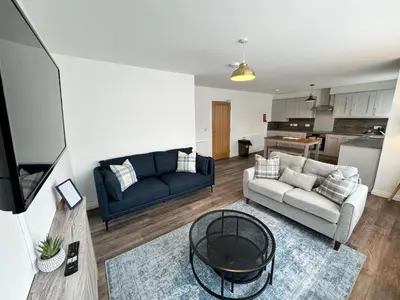 a living room with a couch and a table at Inchmoan Apartment in Bonhill