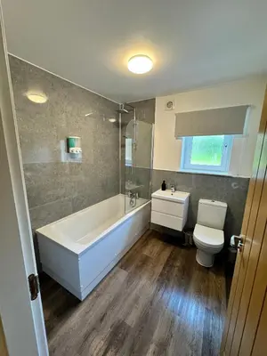 a bathroom with a tub and a toilet and a sink at Inchmoan Apartment in Bonhill