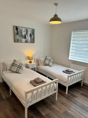 a room with two beds and a window at Inchmoan Apartment in Bonhill