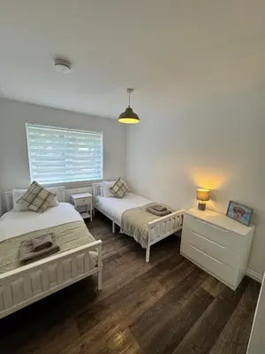 a bedroom with two beds and a window at Inchmoan Apartment in Bonhill