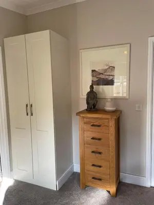 a room with a cabinet and a dresser with a statue on it at Riverbank Lodge in Dollar